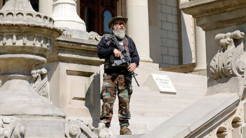 An armed demonstrator attends a rally in support of First Amendment rights at the Michigan State Capitol in Lansing on May 15, 2021.