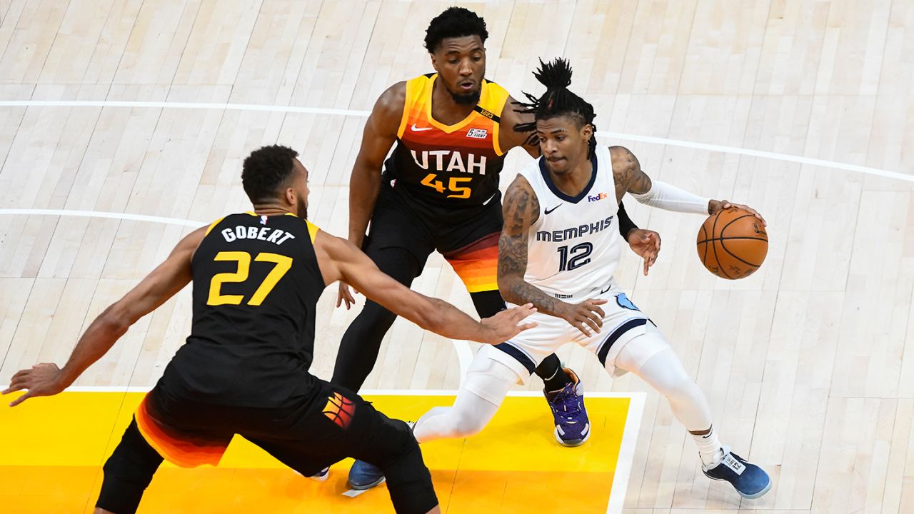 Ja Morant of the Memphis Grizzlies attempts to drive between Donovan Mitchell and Rudy Gobert of the Utah Jazz in Game 2 of the Western Conference first-round playoff series on May 26, 2021.