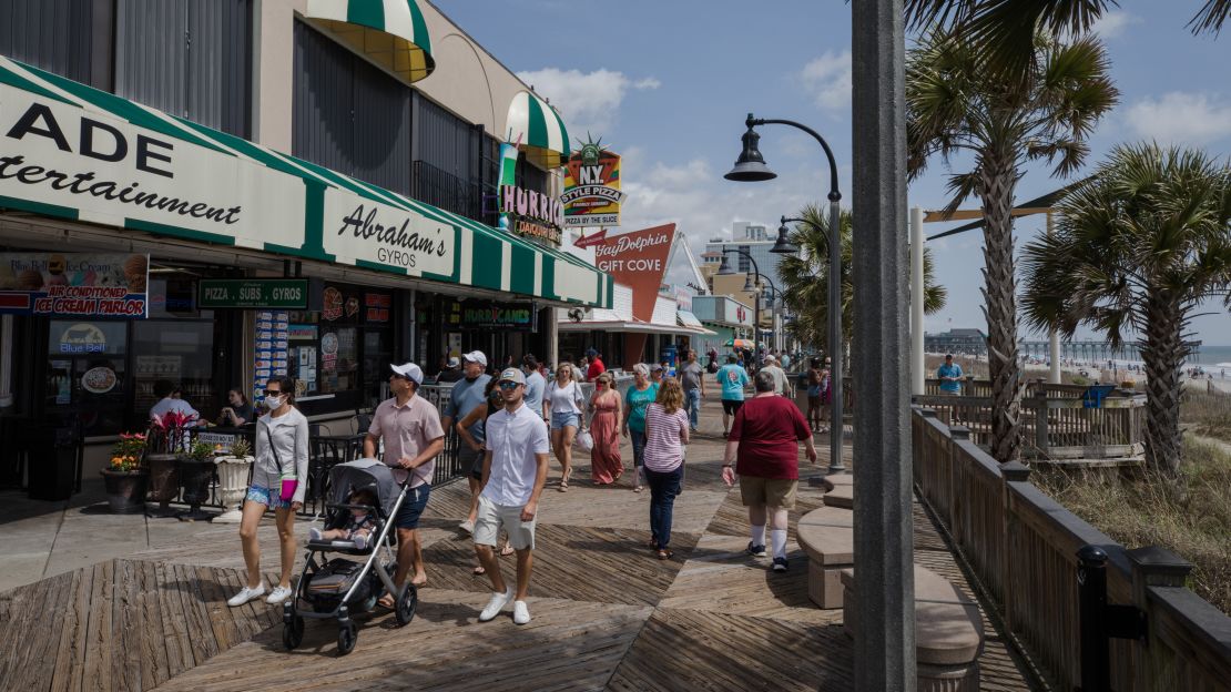 People walk along a boardwalk in Myrtle Beach, South Carolina, on Sunday, April 11, during spring break. 