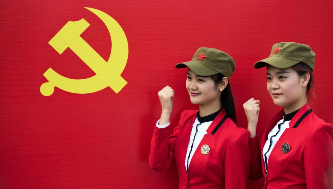 Tourists pose in front a flag of the Communist Party in Shaoshan, in central China's Hunan province in 2016. 