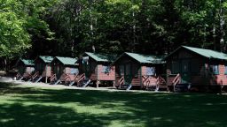FILE - This Thursday, June 4, 2020 file photo shows a row of cabins at a summer camp in Fayette, Maine. On Friday, May 28, 2021, the Centers for Disease Control and Prevention posted guidance saying kids at summer camps can skip wearing masks outdoors, with some exceptions. Children who aren't fully vaccinated should still wear masks outside when they're in crowds or in sustained close contact with others -- and when they are inside, and fully vaccinated kids need not wear masks indoors or outside, the CDC says. (AP Photo/Robert F. Bukaty, File)