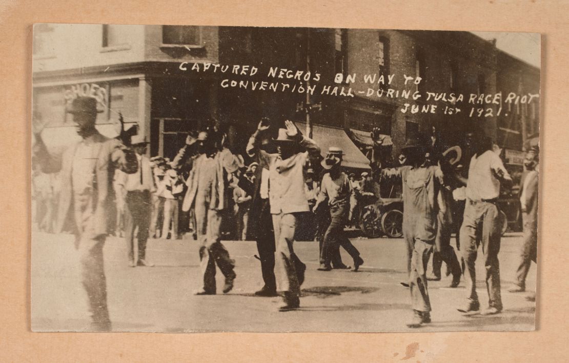 This photograph shows men walking with their hands raised during the Tulsa race massacre on June 1, 1921.