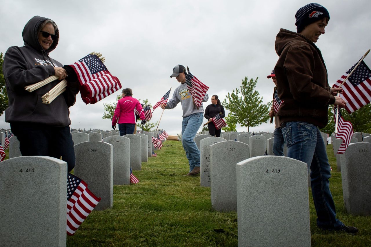 Volunteers place flags at the Iowa Veterans Cemetery in Adel, Iowa, on Friday.
