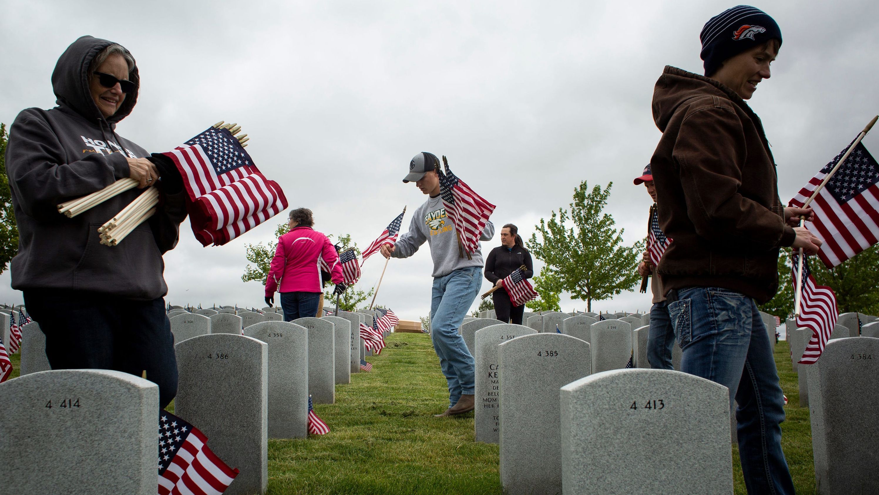 Volunteers place flags at the Iowa Veterans Cemetery in Adel, Iowa, on Friday.