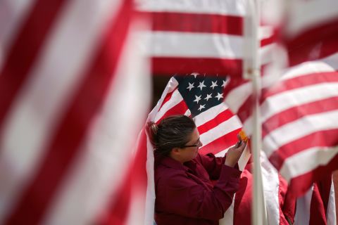 Jacqueline Blair hangs ribbons on flags Friday at the Field of Honor in Idaho Falls, Idaho. A thousand flags will be on display at the Russ Freeman Park through Memorial Day.