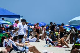 People relax on the sand during the Memorial Day Hyundai Air and Sea Show in Miami Beach, Florida on May 29, 2021.