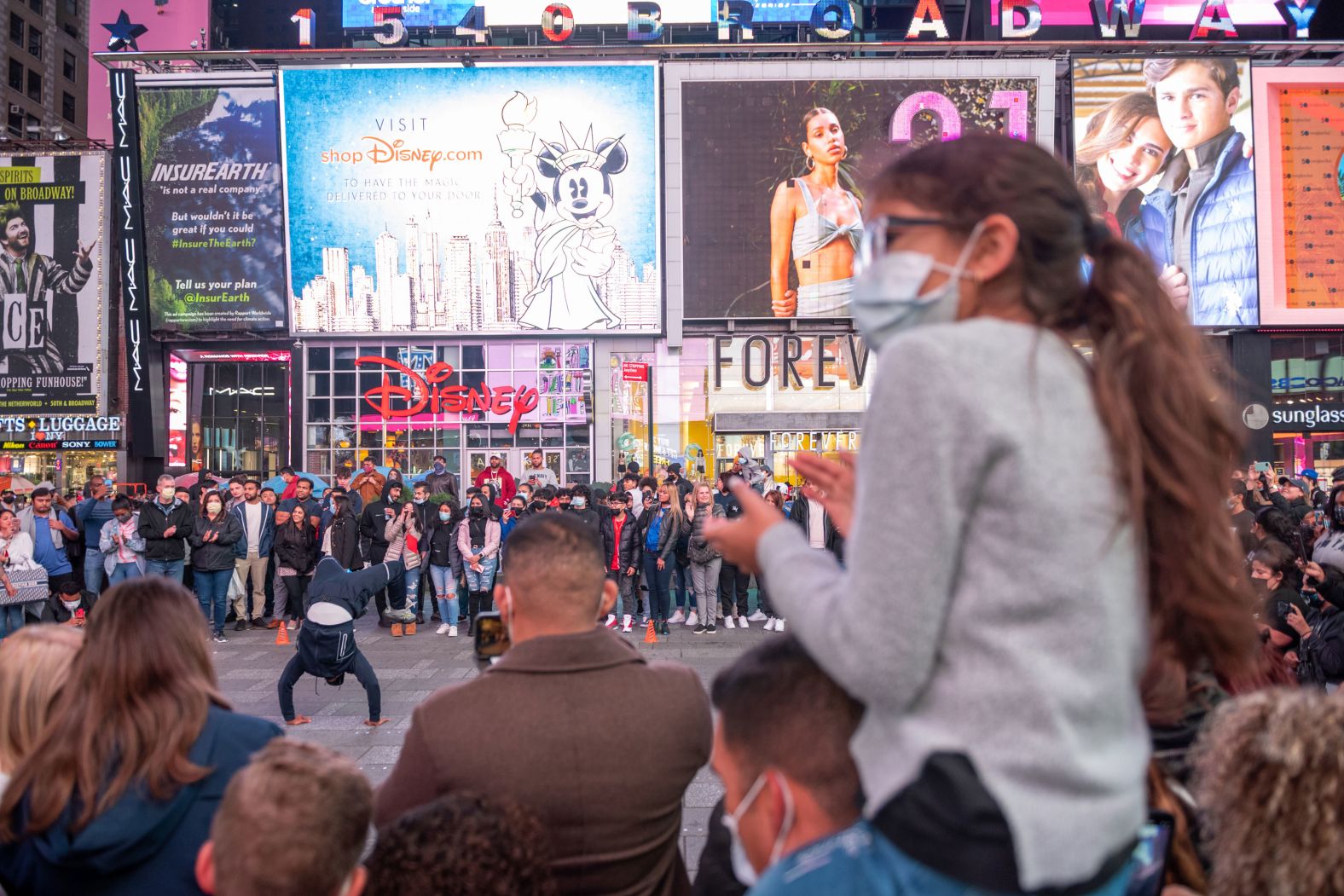 A large crowd gathers to watch a street performance in New York's Times Square on Saturday.