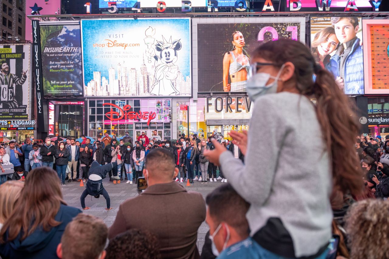 A large crowd gathers to watch a street performance in New York's Times Square on Saturday.