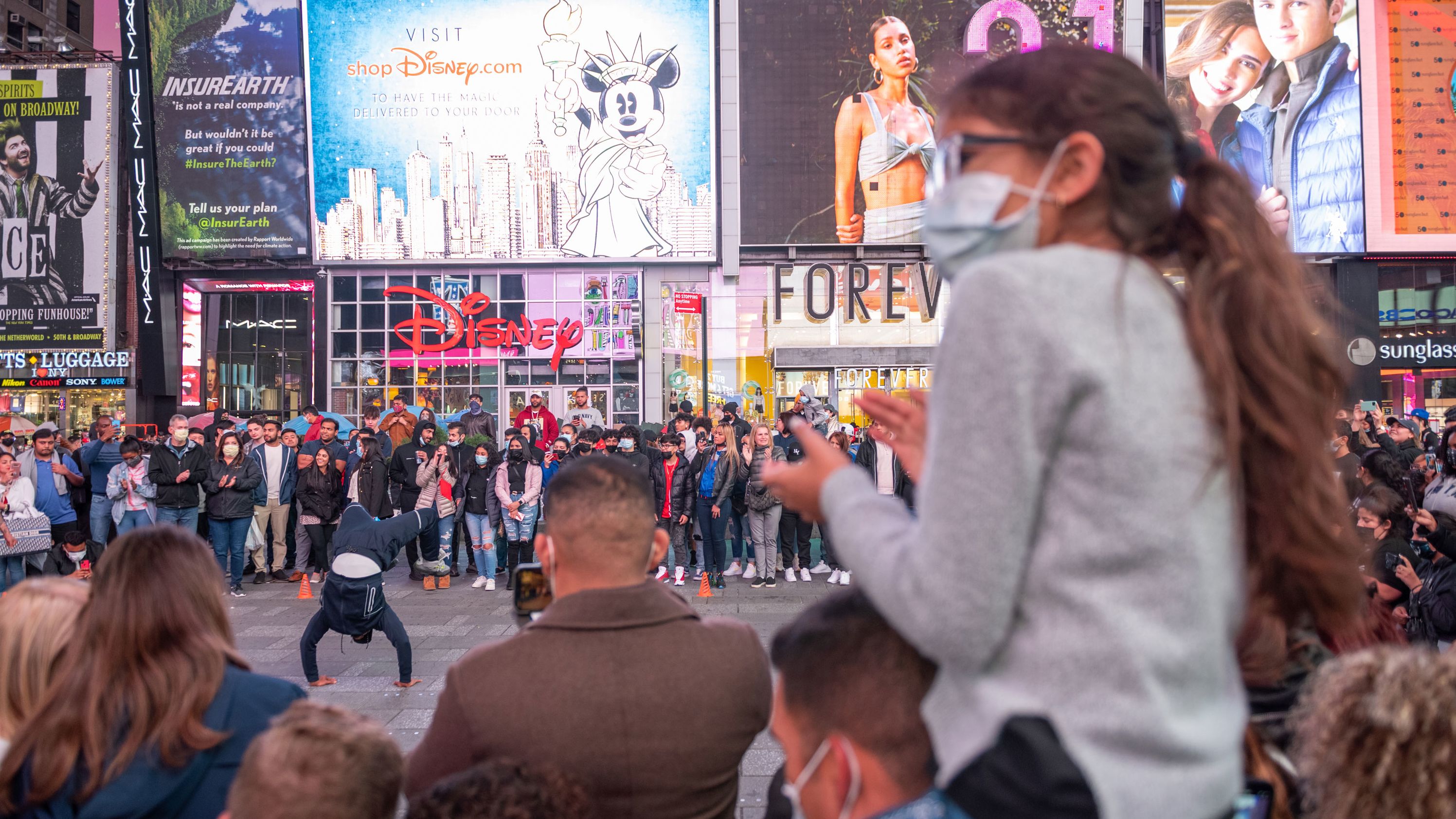 A large crowd gathers to watch a street performance in New York's Times Square on Saturday.