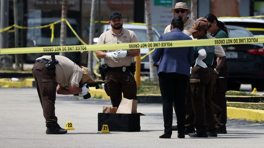 HIALEAH, FLORIDA - MAY 30: Miami-Dade police officers collect evidence near shell case evidence markers where a mass shooting took place outside of a banquet hall on May 30, 2021 in Hialeah, Florida. Police say that two people died, and an estimated 20 to 25 people are injured after the shooting at the banquet hall rented out for a concert. (Photo by Joe Raedle/Getty Images)