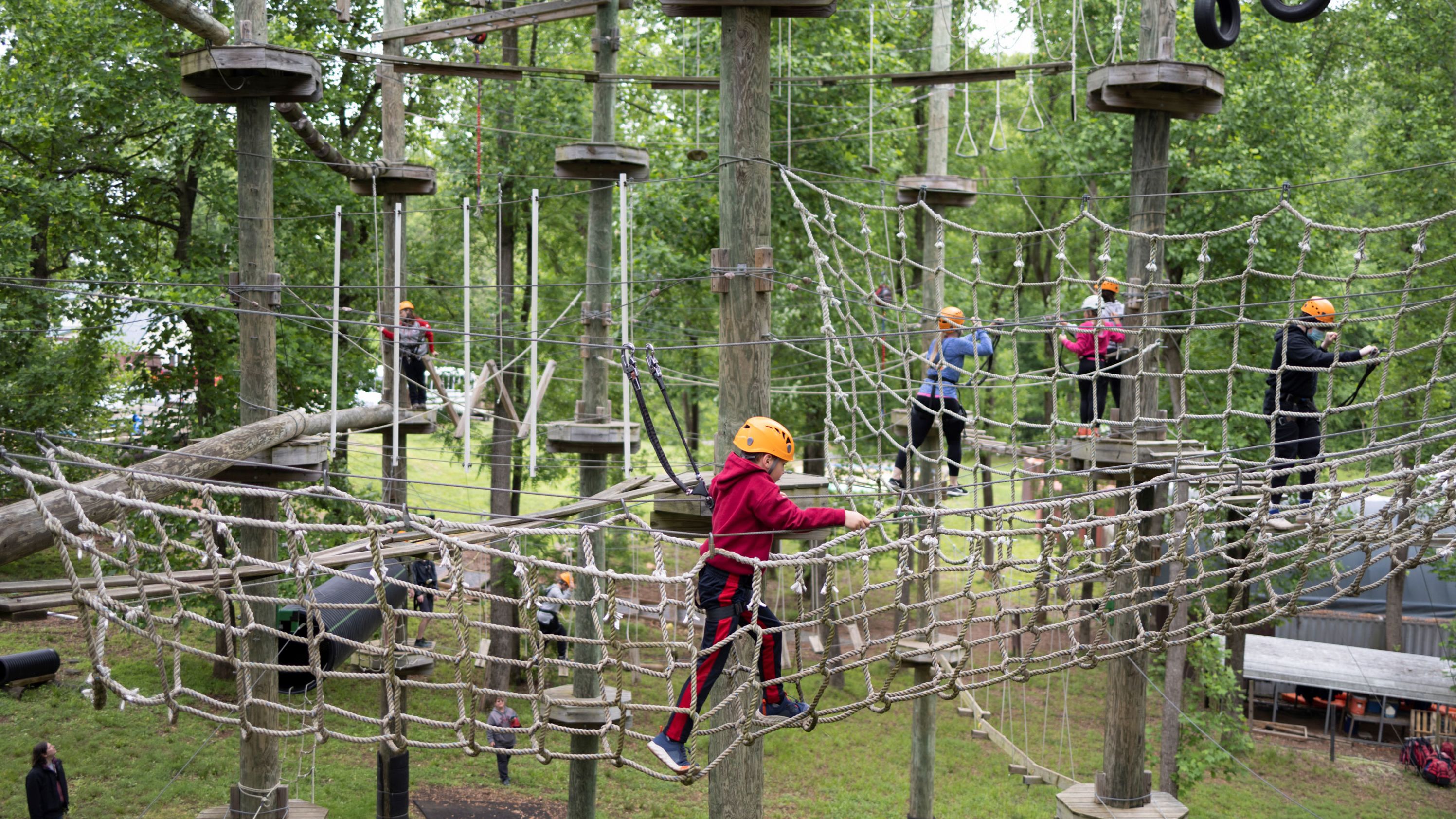 A boy makes his way through the aerial ropes course at Harpers Ferry Adventure Center in Hillsboro, Virginia, on Sunday.