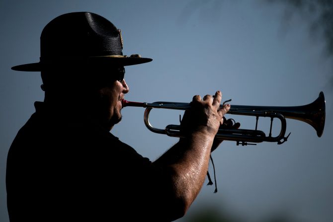 Bugler David Bonczkiewicz plays with the honor guard Monday at the National Memorial Cemetery of Arizona.