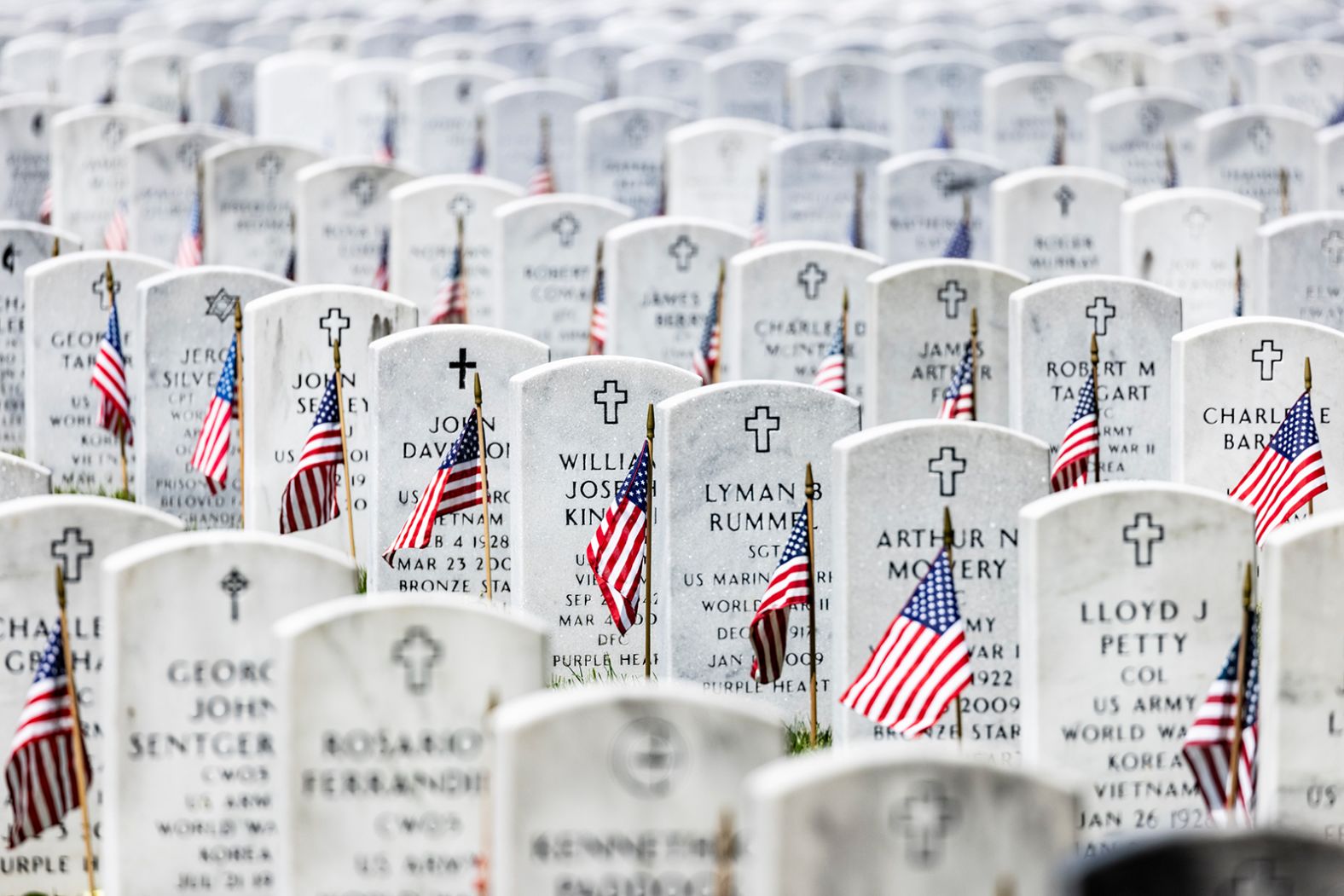 American flags are placed next to the headstones in Arlington National Cemetery.