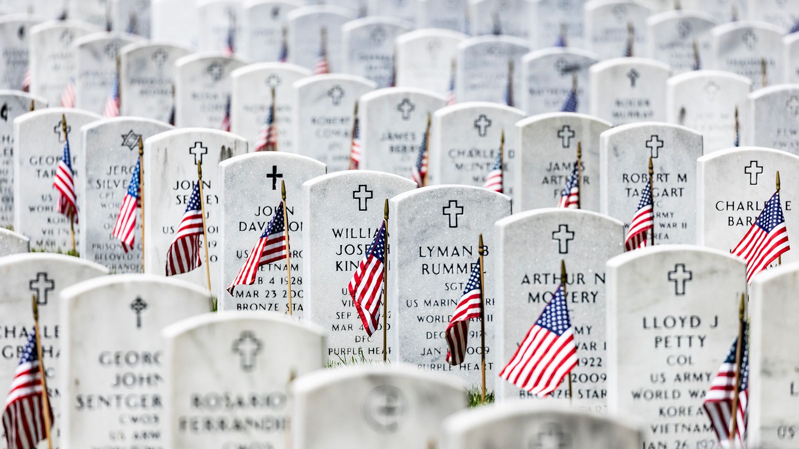 American flags are placed next to the headstones in Arlington National Cemetery.