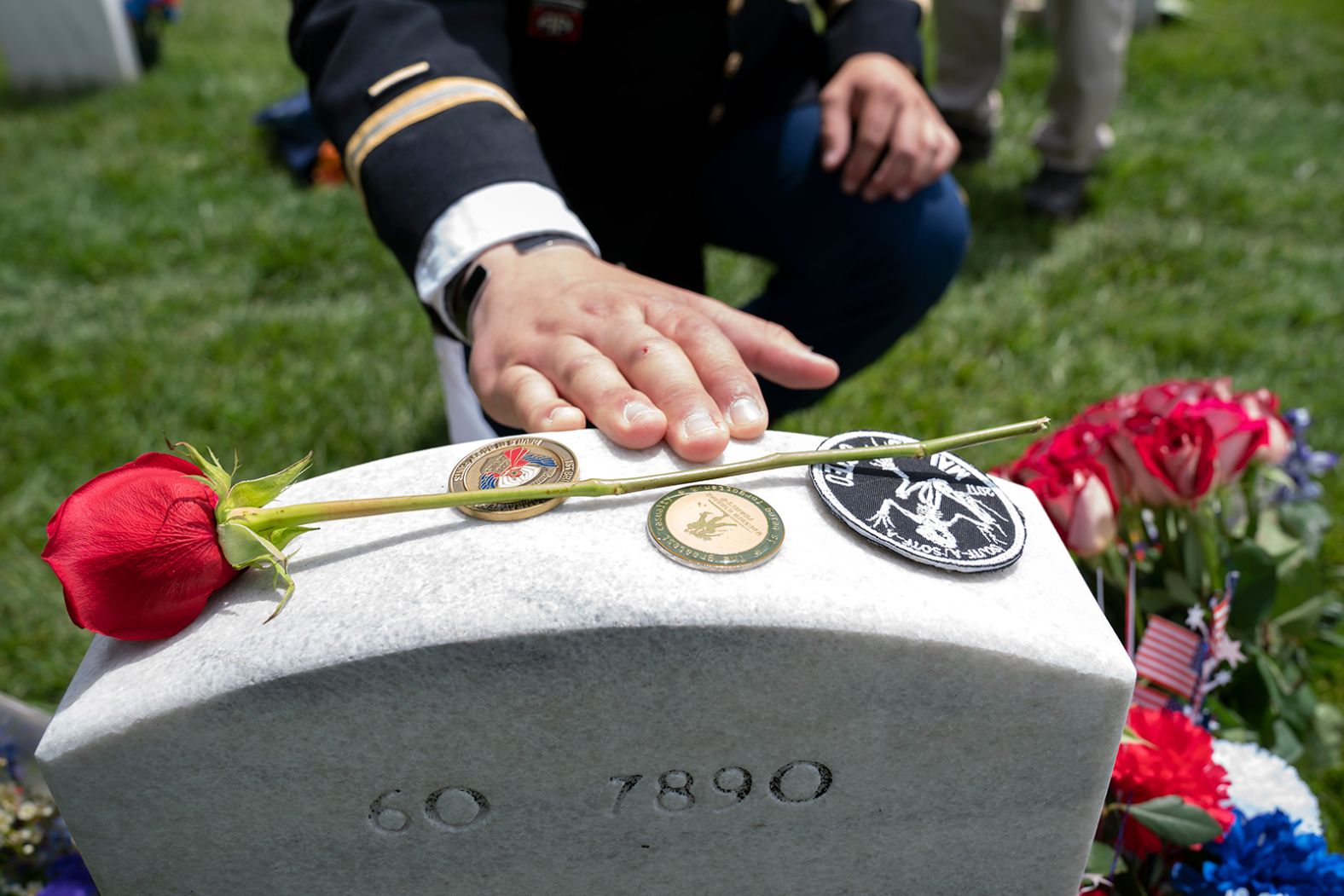 Army Capt. Darren M. Cinatl touches the headstone of his friend Andrew Joseph Baddick at Arlington National Cemetery.