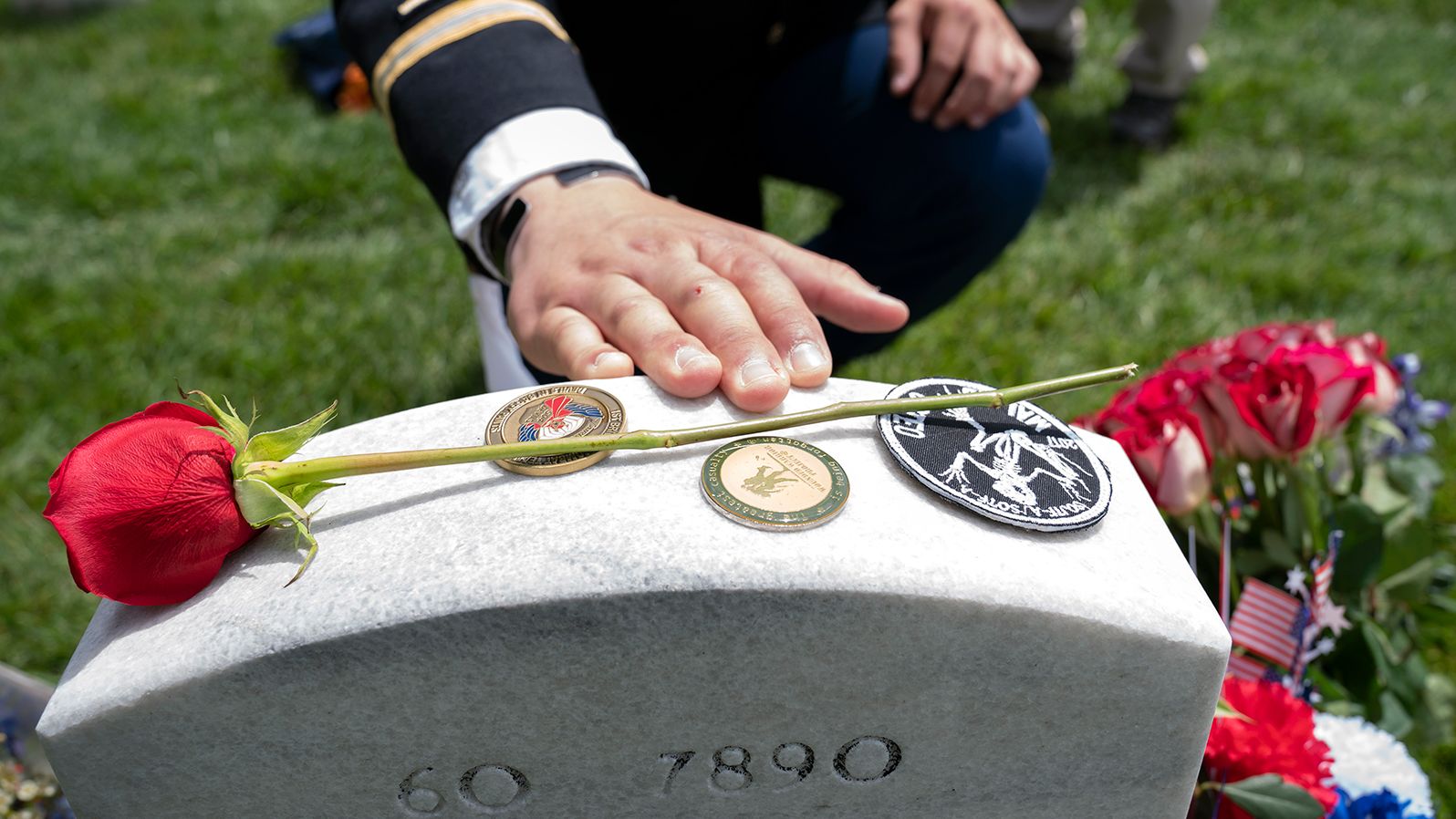 Army Capt. Darren M. Cinatl touches the headstone of his friend  Andrew Joseph Baddick at Arlington National Cemetery.