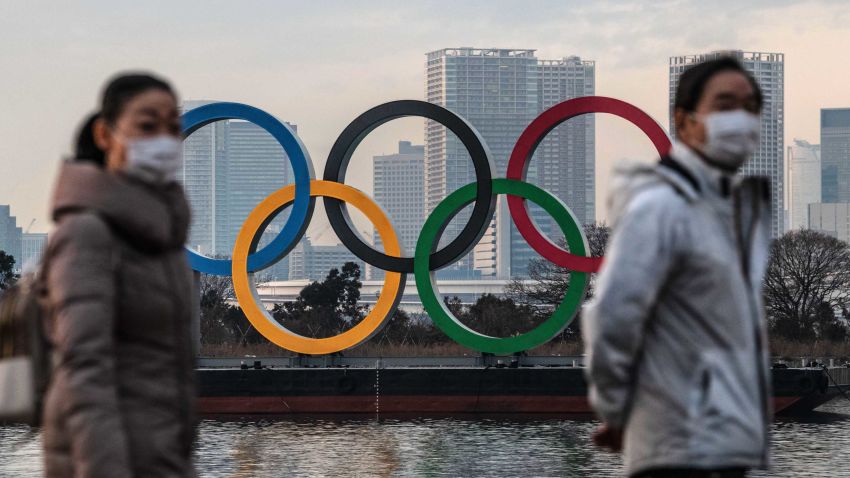 TOKYO, JAPAN - JANUARY 22: People wearing face masks walk past the Olympic Rings on January 22, 2021 in Tokyo, Japan. With just six months to go until the start of the Games, it has been reported that the Japanese authorities have privately concluded that the Olympics could not proceed due to the ongoing Covid-19 coronavirus pandemic. Spokesmen from the IOC and Japanese government have since rejected the report. (Photo by Carl Court/Getty Images)