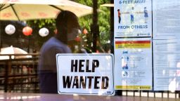 A 'Help Wanted' sign is posted beside Coronavirus safety guidelines in front of a restaurant in Los Angeles, California on May 28, 2021. - 