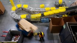 An employee pulls a pallet jack past plastic crates moving along a conveyor at the Amazon.com Inc. fulfillment center in Robbinsville, New Jersey, U.S., on Thursday, June 7, 2018. Seattle-based Amazon hasn't yet announced the exact date for this year's Amazon Prime Day, the e-commerce giants big July sales promotion. Photographer: Bess Adler/Bloomberg via Getty Images