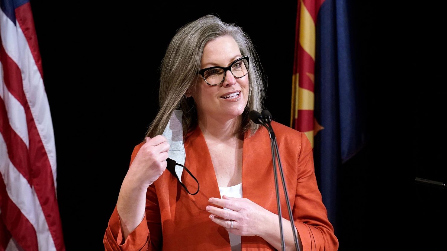 In this December 2020 photo, Arizona Secretary of State Katie Hobbs removes her face mask as she addresses the members of Arizona's Electoral College prior to them casting their votes, in Phoenix. 