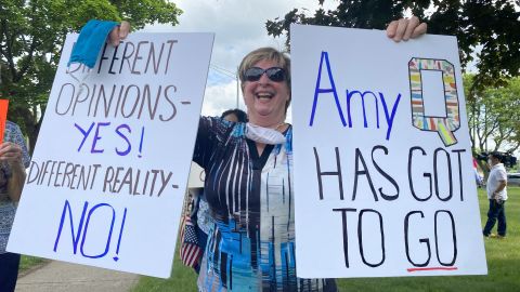 Protesters made signs calling Fachinello "Amy Q" because of the controversy surrounding her QAnon-related posts.