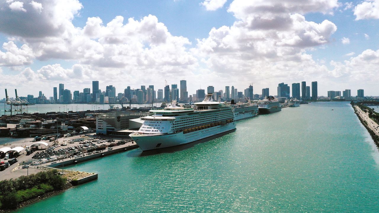 MIAMI, FLORIDA - MAY 26:  In an aerial view, Explorer of the Seas (front), a Royal Caribbean cruise ship, along with other cruise ships are docked at PortMiami as the cruise line industry waits to begin operations again on May 26, 2021 in Miami, Florida. In late June, the Royal Caribbean cruise line will be allowed to operate test cruises out of South Florida after receiving approval from the U.S. Centers for Disease Control and Prevention. The test cruises will show whether ships can sail safely and follow CDC guidelines to prevent the spread of COVID-19. (Photo by Joe Raedle/Getty Images)