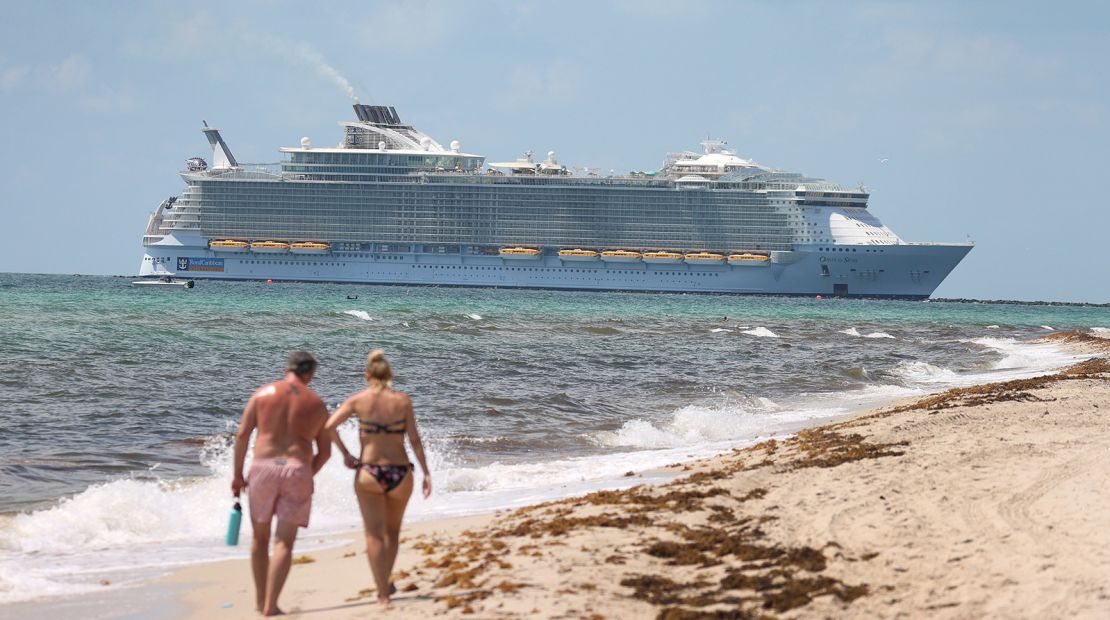 Royal Caribbean's Oasis of the Seas sails past beachgoers as it prepares to dock at PortMiami on May 28, 2021.