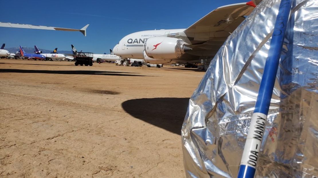 A Qantas 'wheel whacker' rests against the tire of an A380 parked in the Mojave Desert.