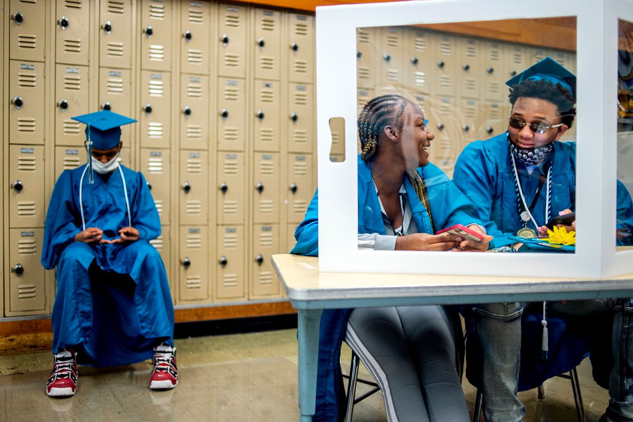 From left, Jeremy Purcell, Rere Thomas and Jaireese Woodall wait in the back before their high school commencement ceremony began at a gymnasium in Flint, Michigan, on Wednesday, June 2.