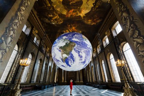 "Gaia," a giant globe installation by Luke Jerram, hangs over a staff member at the Old Royal Naval College in London on Tuesday, June 1. The internally lit replica of Earth uses NASA imagery and rotates.