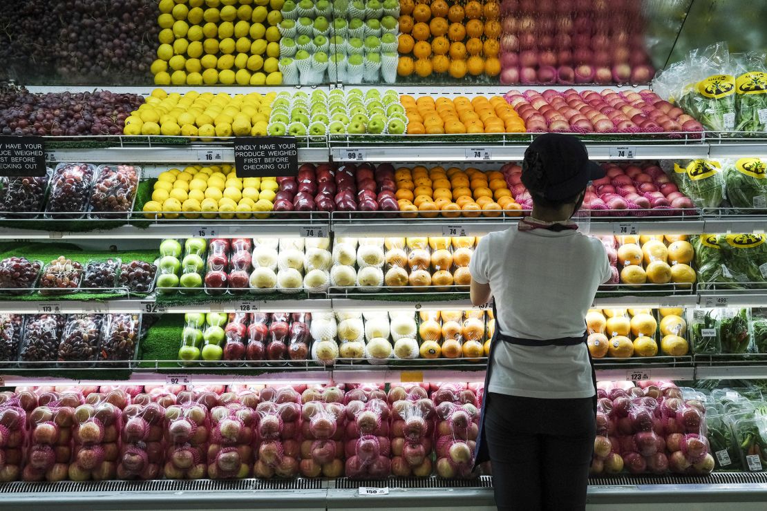 A sales assistant arranges fruit at the fresh produce section in the supermarket at the SM City Bacoor shopping mall in Bacoor, Cavite province, the Philippines, on June 3, 2021.