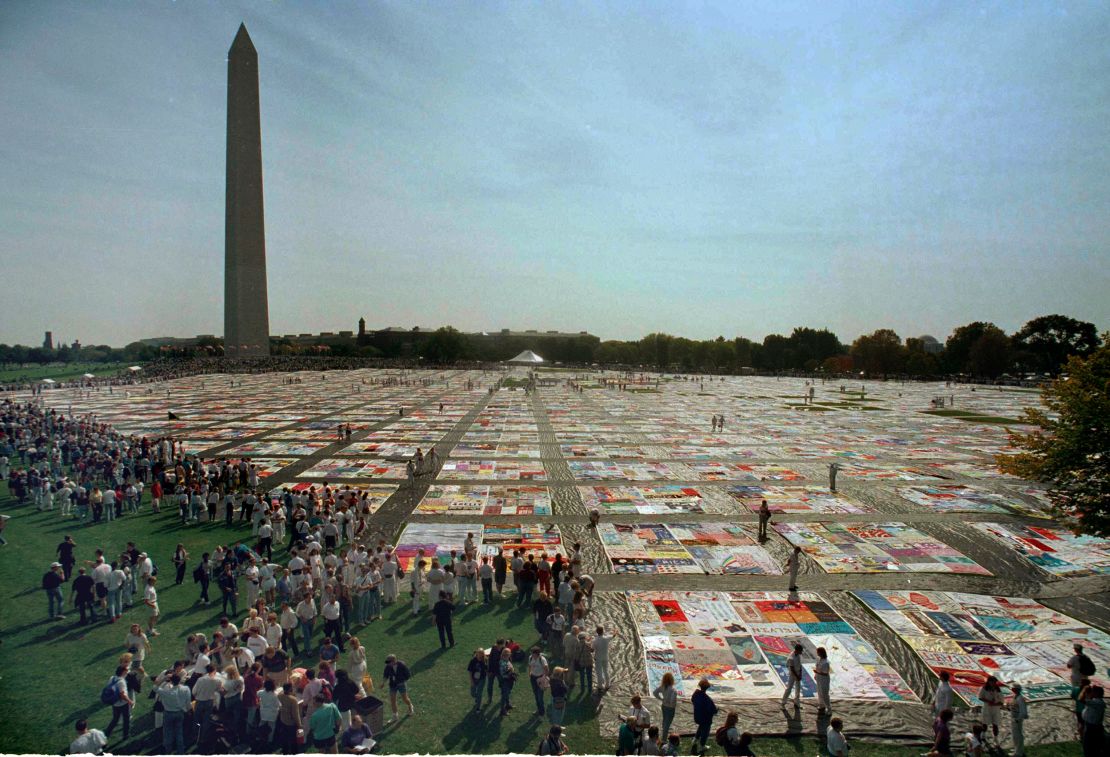 Visitors and volunteers walk on the 21,000-panel AIDS Memorial Quilt on October 10, 1992 in Washington.