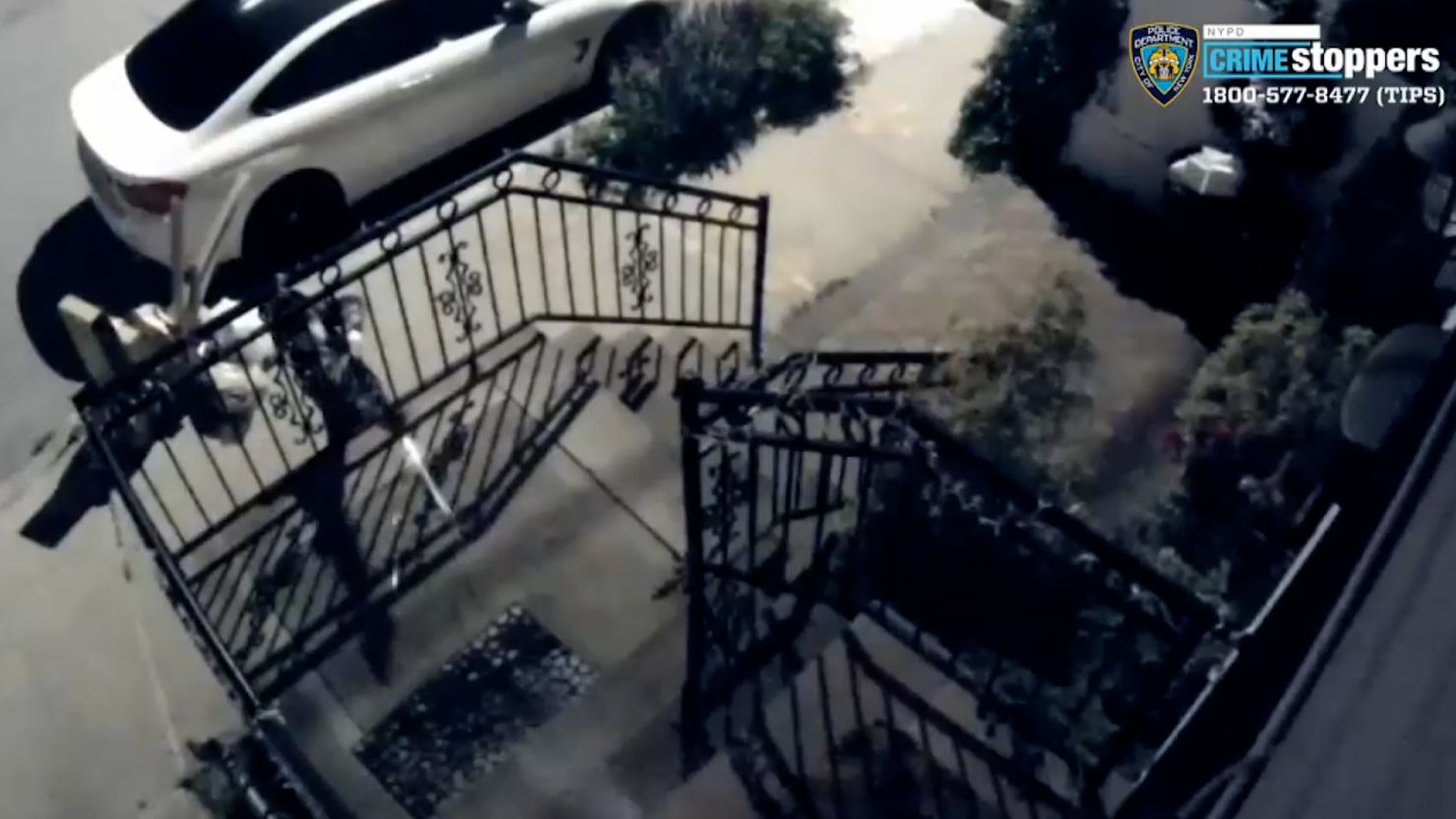 The NYPD has released video showing a male approaching a house in the Far Rockaway neighborhood of Queens Saturday night and shooting multiple rounds through a stair railing before fleeing.