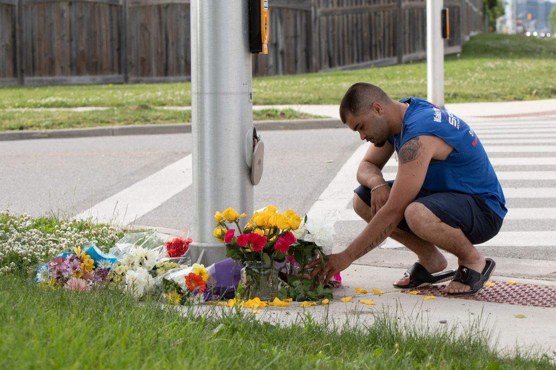 A man places flowers and pays his respects at the scene in London, Ontario, on Monday, June 7. 