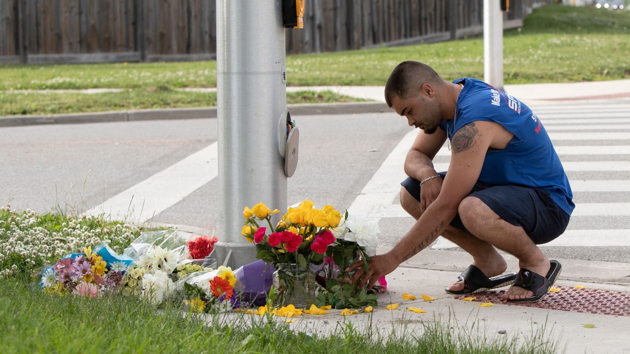 A man places flowers and pays his respects at the scene in London, Ontario, on Monday, June 7.