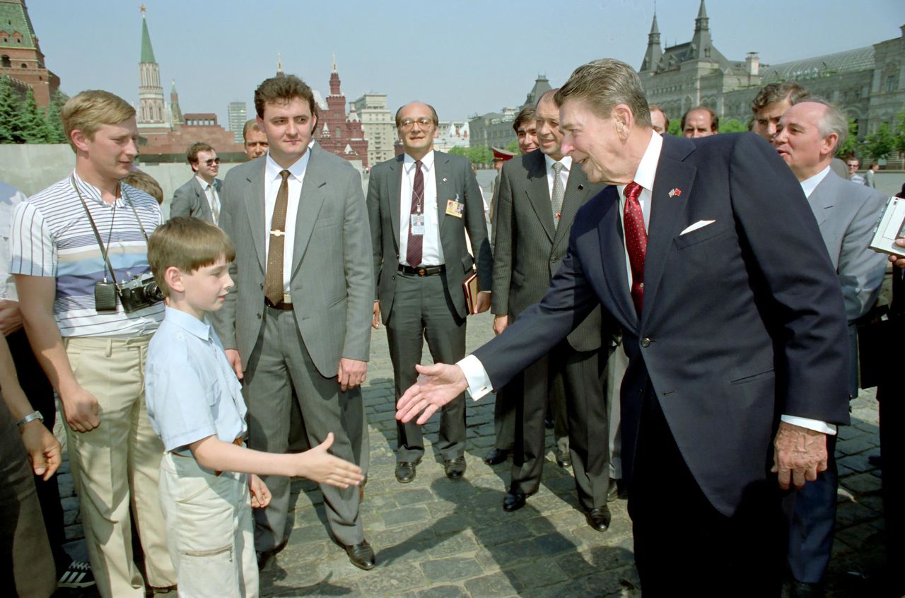 Reagan shakes a boy's hand as he tours Moscow's Red Square with Gorbachev in 1988.