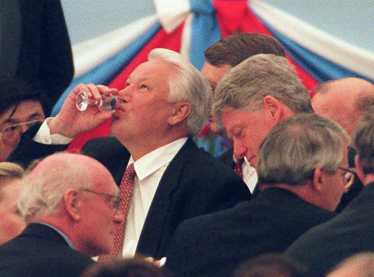 Russian President Boris Yeltsin finishes a glass of vodka in Moscow during a reception for world leaders in 1995. On the right is US President Bill Clinton.