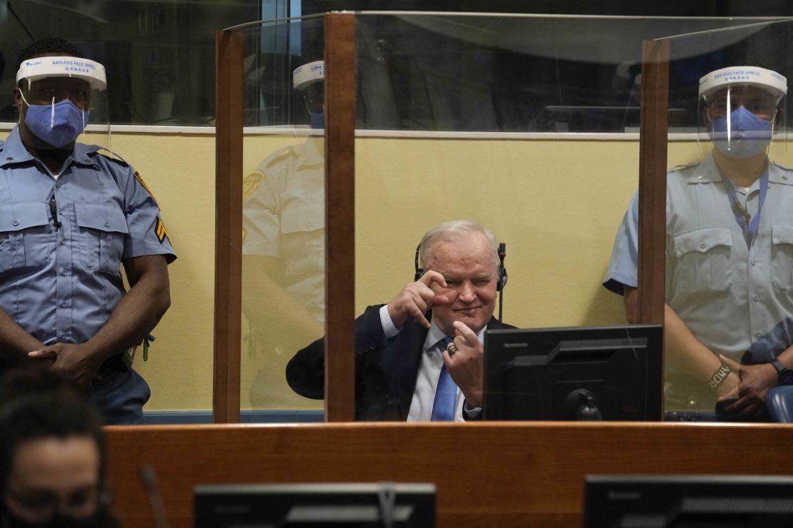 Mladic imitates taking pictures as he sits in the defendant box prior to the hearing of the final verdict on June 8.