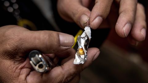A motorbike taxi driver holds a methamphetamine pill in January in Bangkok.