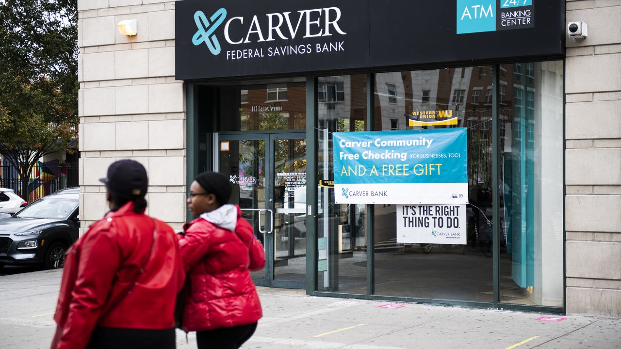 Pedestrians walk past a Carver Federal Savings Bank branch in the Harlem neighborhood of New York, U.S., on Oct. 27, 2020.