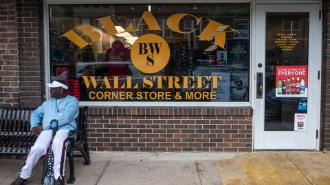 A man sits in front of a store the Greenwood neighborhood in Tulsa, Oklahoma, on May 31, 2021.