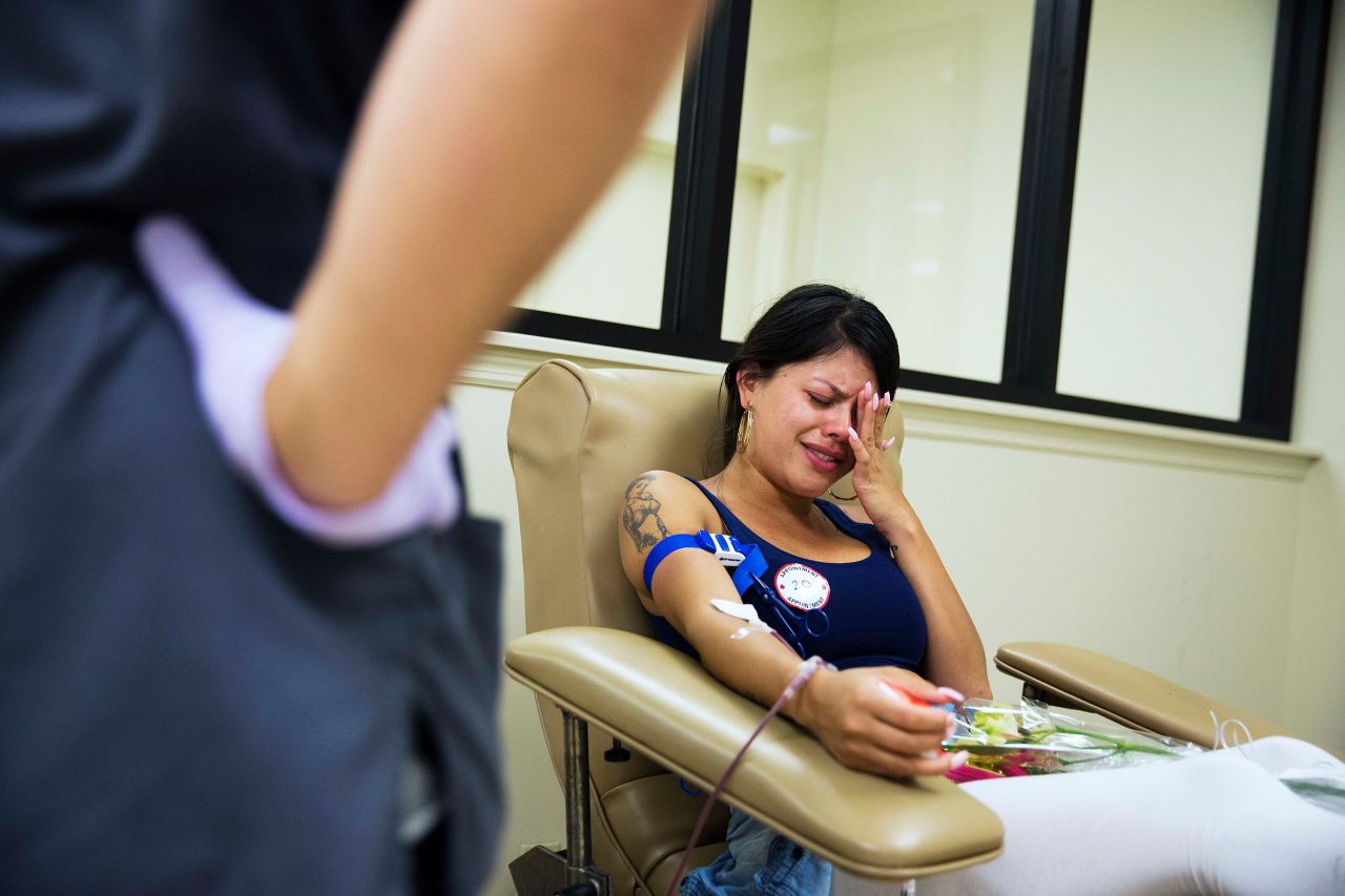 Tatiana Osorio cries while giving blood at a donation center in Orlando. She lost three friends in the shooting.