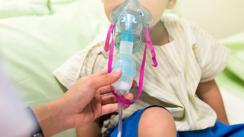 A 3-year-old patient in the hospital receives medication via an inhalation mask to treat Respiratory Syncytial Virus (RSV).