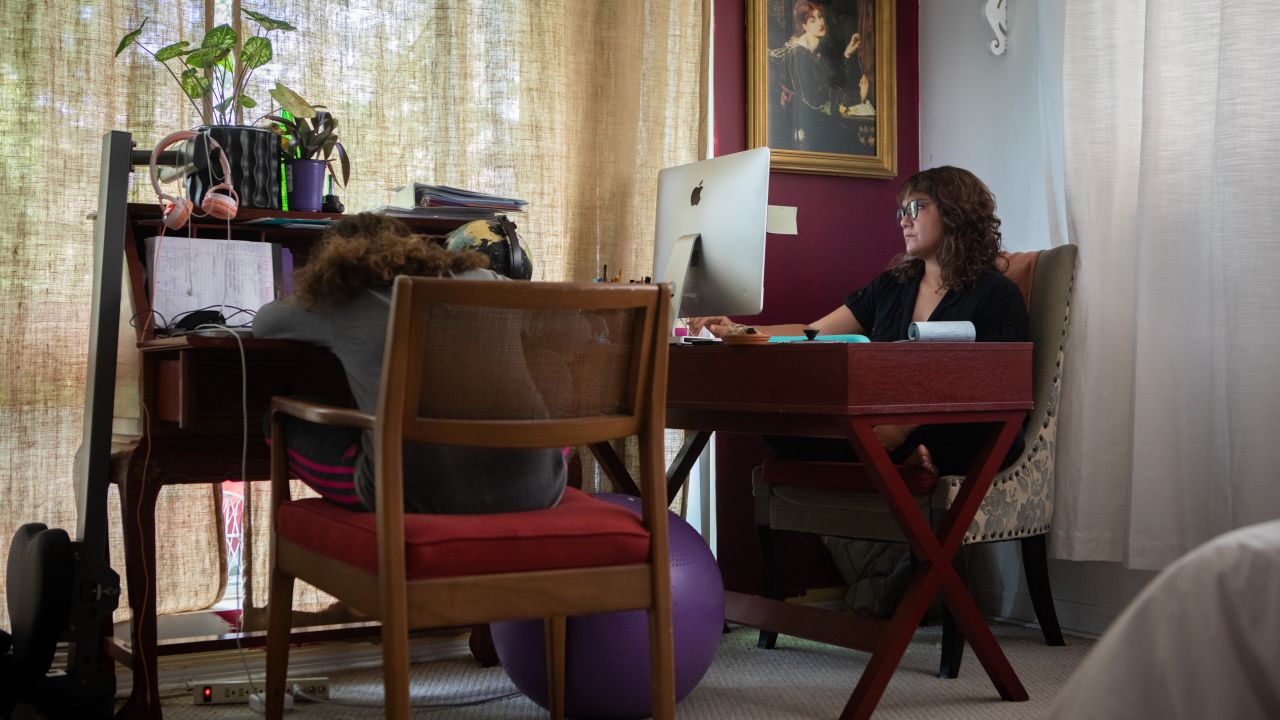 A mother teleworks while her daughter virtually attends school at their home in Miami Beach on September 8, 2020.