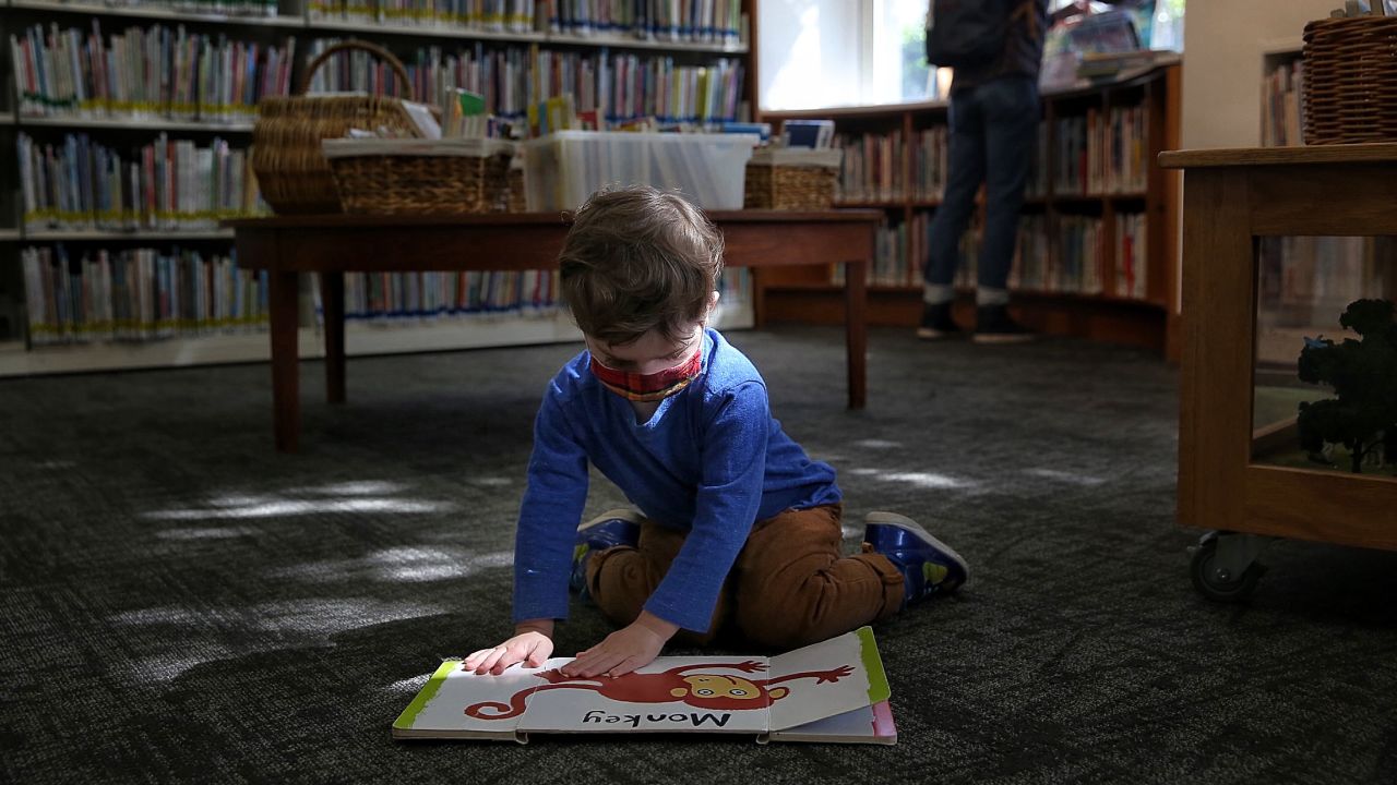 Libraries are slowly re-opening. Two-year-old Frank visited the Oakland Public Library's Rockridge Branch with his father.