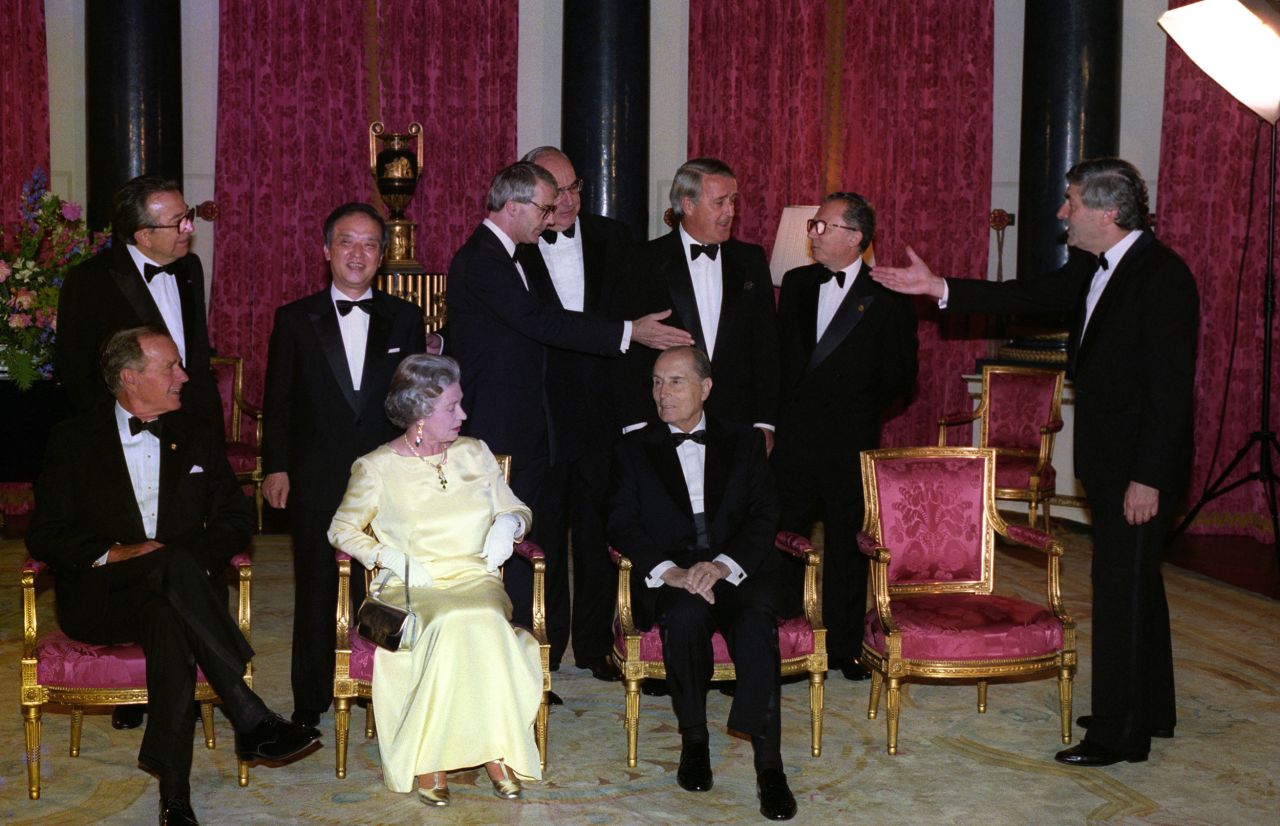 World leaders gather for a photo in the Music Room at Buckingham Palace during the 17th G7 summit on July 16, 1991. From left, Italian Prime Minister Andreotti, Japanese Prime Minister Toshiki Kaifu, British Prime Minister John Major, German Chancellor Kohl, Canadian Prime Minister Mulroney, President of the European Commission Delors, and Netherlands Prime Minister Ruud Lubbers are seen standing. Bush, Queen Elizabeth II, and Mitterrand sit in the front.