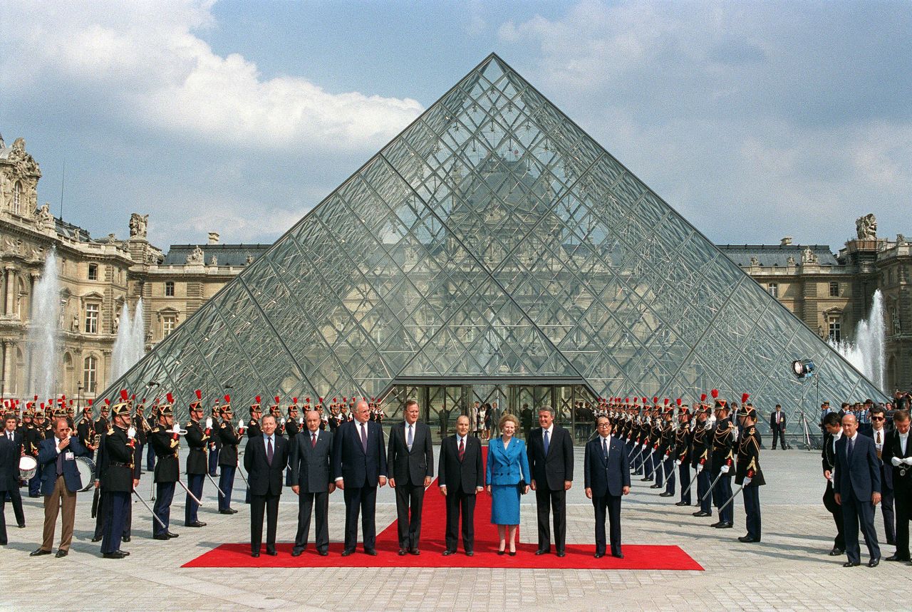 President of the European Commission Jacques Delors, Italian Prime Minister Ciriaco de Mita, German Chancellor Helmut Kohl, US President George H.W. Bush, French President Mitterrand, British Prime Minister Thatcher, Canadian Prime Minister Brian Mulroney, and Japanese Prime Minister Sōsuke Uno pose for a photo in front of the Louvre Pyramid in Paris during the 15th G7 summit in 1989.