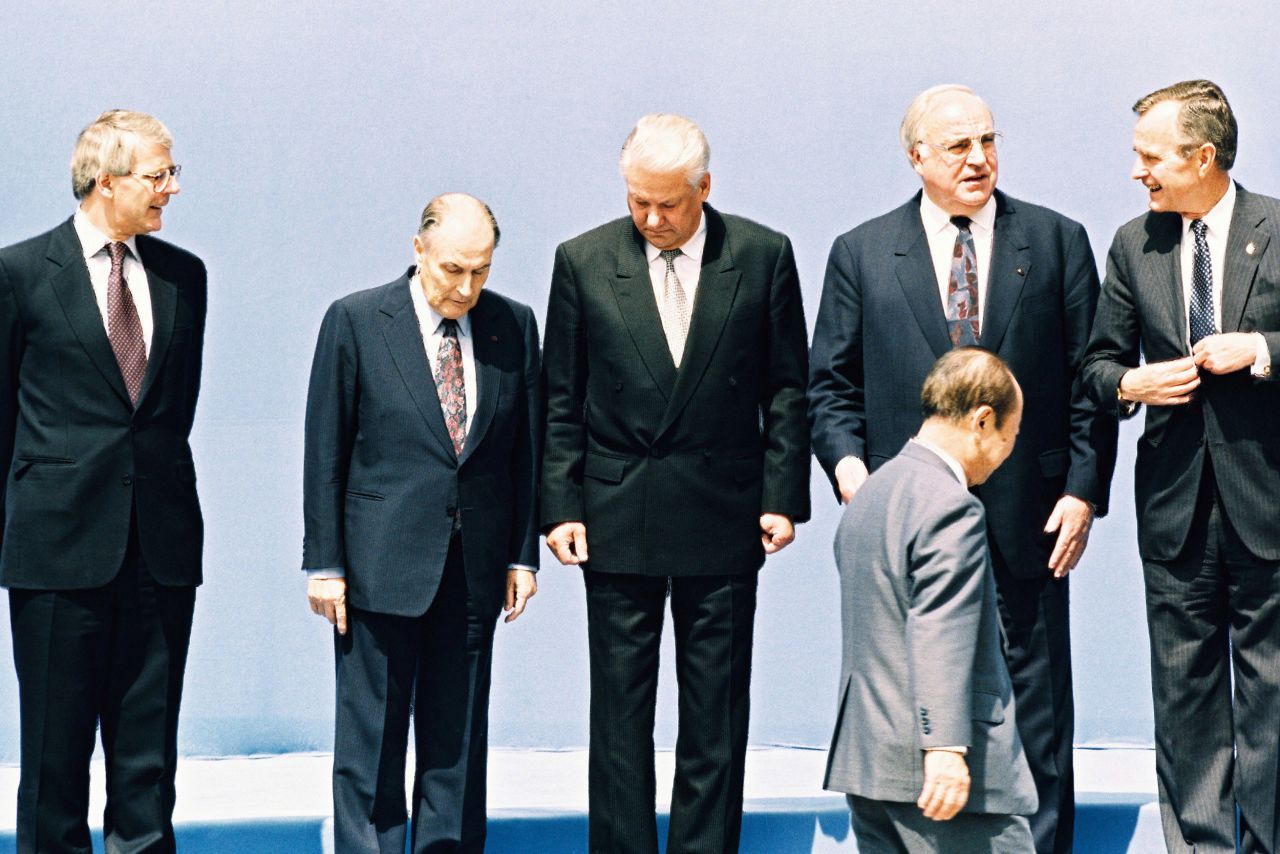 Major, Mitterrand, Russian President Borris Yeltsin, German Chancellor Kohl and US President Bush stand as Japanese Prime Minister Kiichi Miyazawa walks to his place for a photo at the 18th G7 Summit in Munich in 1992.