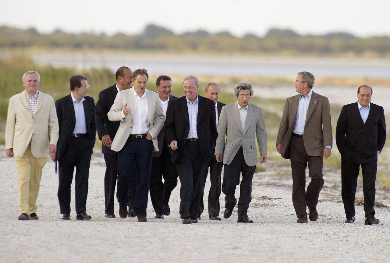 Leaders walk on the beach in Sea Island, Georgia, at the 30th G8 Summit in 2004. From left are President of the Council of the European Union and Prime Minister of Ireland Bertie Ahern, President of the European Commission Romano Prodi, French President Chirac, British Prime Minister Tony Blair, German Chancellor Gerhard Schroeder, Canadian Prime Minister Paul Martin, Russian President Vladimir Putin, Prime Minister of Japan Junichiro Koizumi, US President George W. Bush, and Italian Prime Minister Silvio Berlusconi. The G7 changed to G8 in 1997 after inviting Russia to the summit. The name changed back to G7 in 2014 when Russia was disinvited.