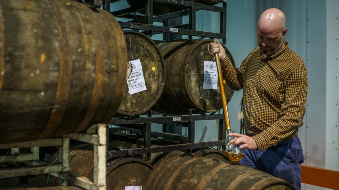 Town Branch Distillery's blender and distiller Alan Kennedy uses a whiskey thief to extract bourbon from a freshly tapped barrel.